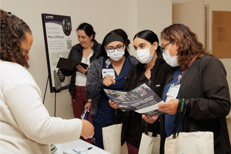 AHS Employees learning about AHS Foundation at tabling event